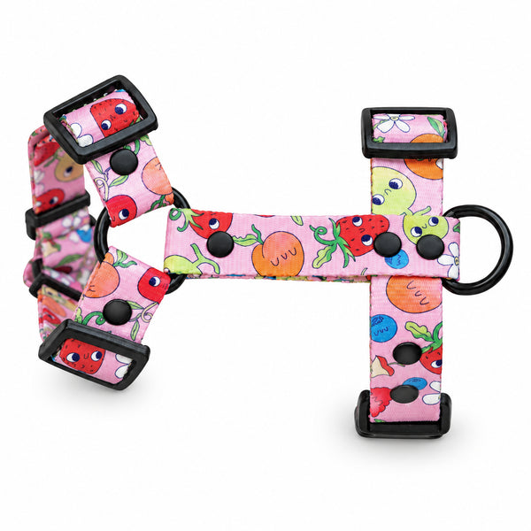 Pink Sweet Tooth dog harness with colourful smiling faces, black adjusters and a black metal D-ring.