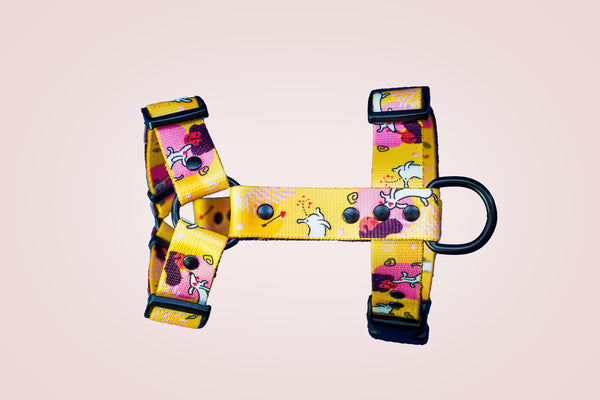 Wet Nose, Warm Heart yellow dog harness laid flat on a pale pink background