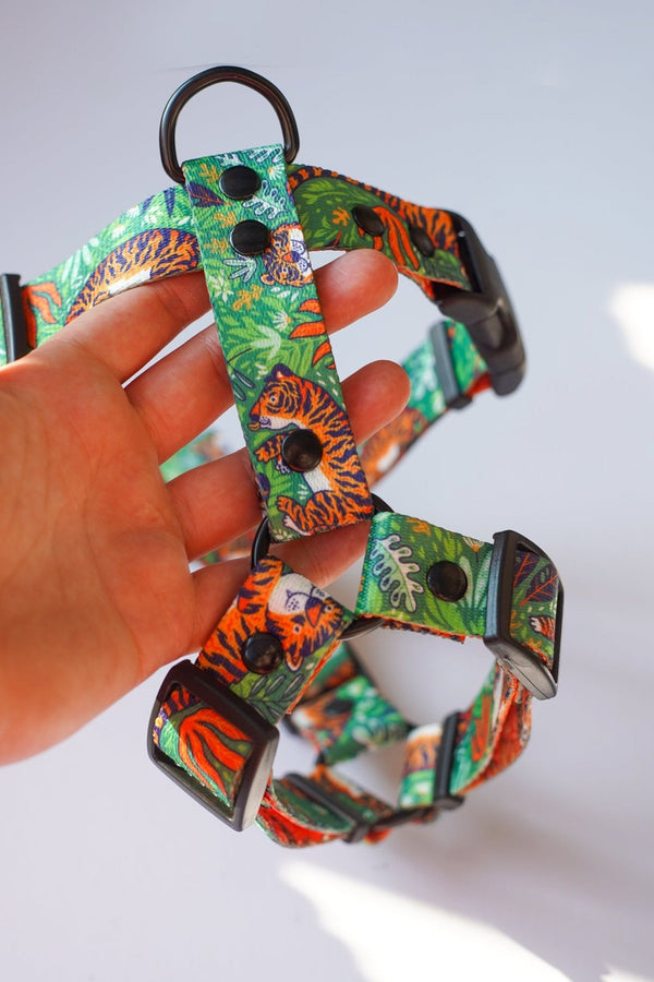 Green Let's Get Wild tiger-print harness held up to show its adjustable straps