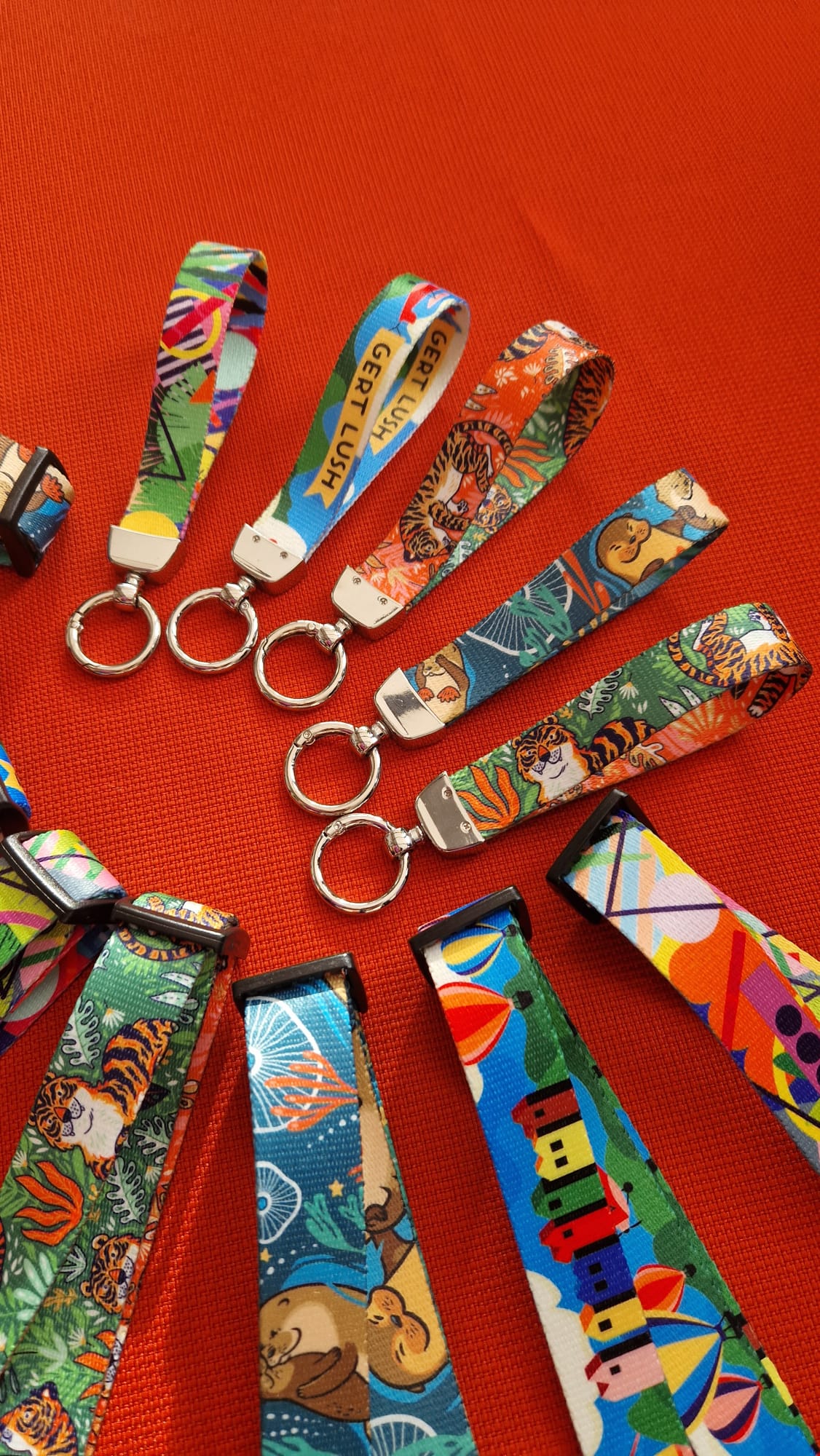 Five fabric wristlet keychains with silver rings in geometric, Bristol, tiger and otter prints