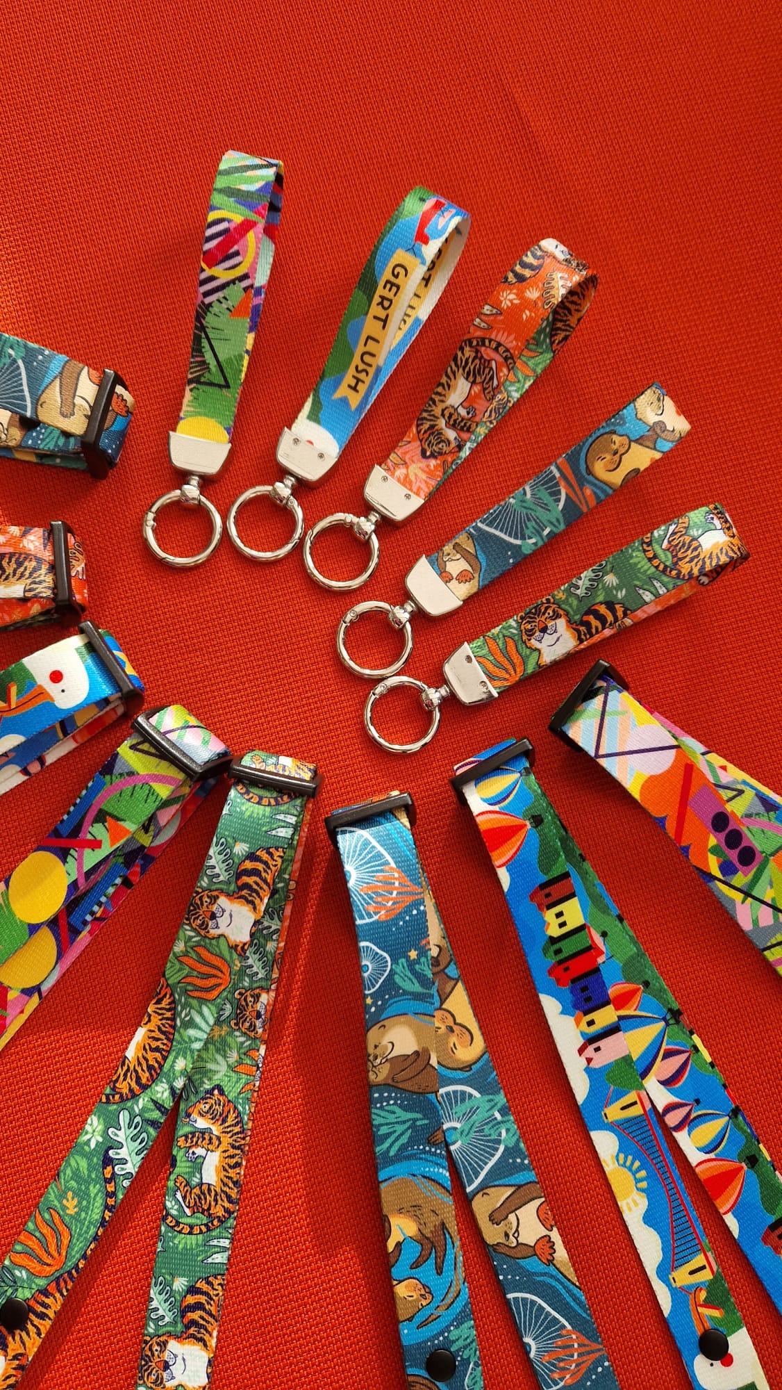 Printed wristlet keychains beside matching dog car seat belts in blue, turquoise, orange and green