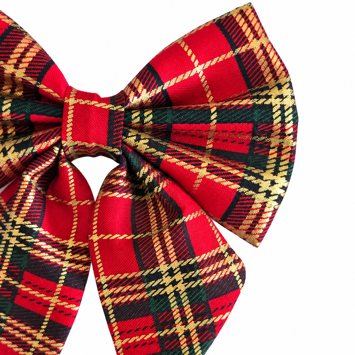 Close-up of the red tartan Christmas dog bow tie showing gold checks, fabric folds and sailor bow tails.